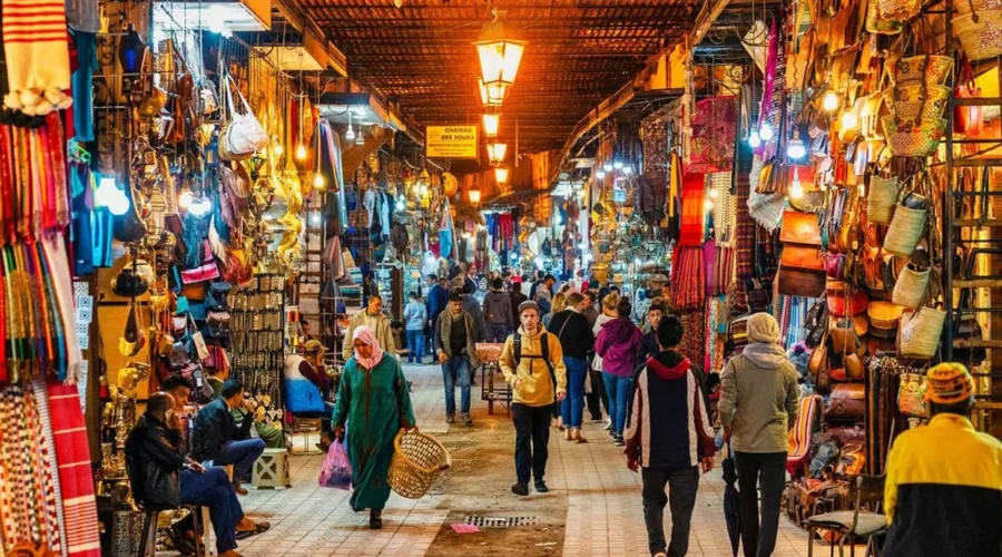 A bustling market scene in the old city of Marrakesh, showcasing vibrant stalls and traditional Moroccan architecture.