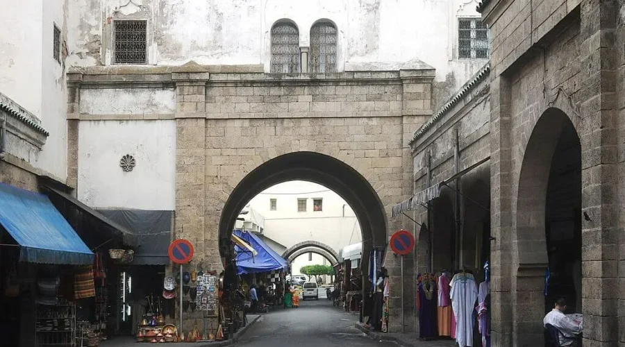 A narrow street lined with shops, featuring elegant arches that create a charming and inviting atmosphere.