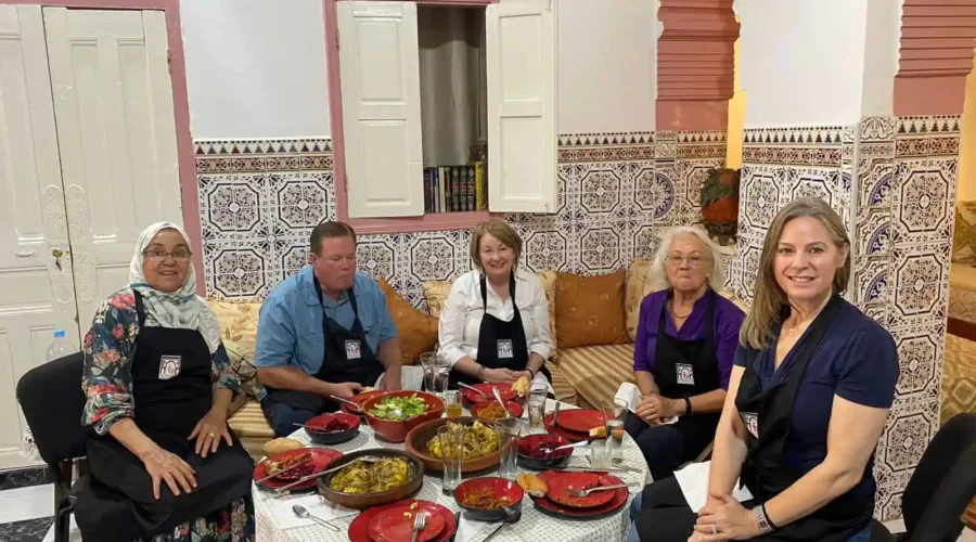 A diverse group of individuals gathered around a table, enjoying a meal together in a warm and inviting setting.